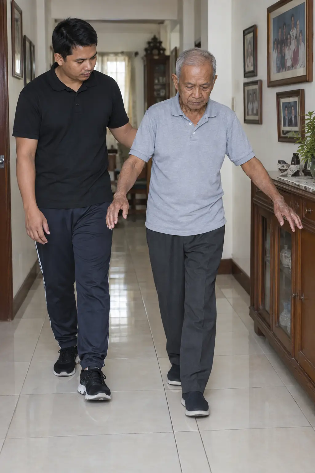 An older Filipino man walking heel to toe along a tiled hallway with one arm out for balance, a Filipino coach walking beside him